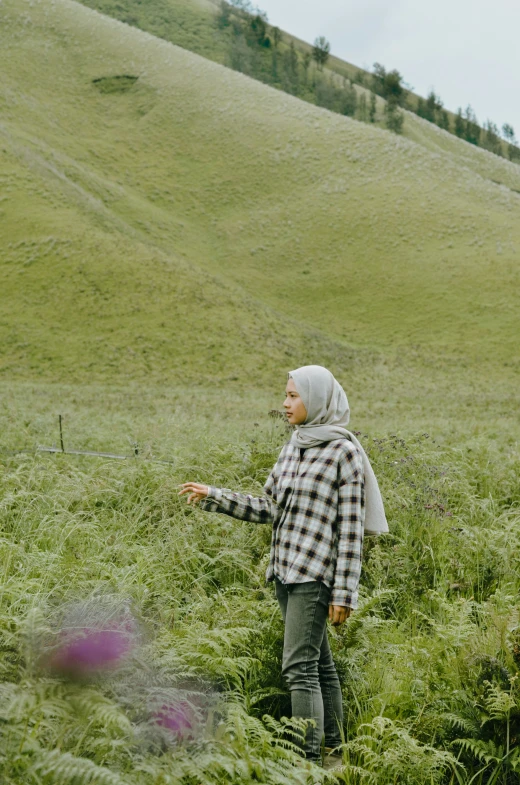 woman in plaid shirt standing in tall grass