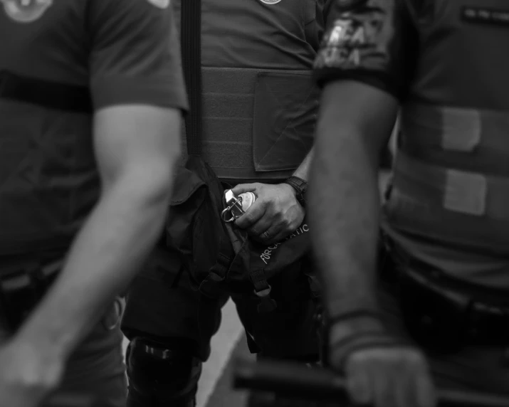 two police men wearing their gear and holding onto their hands