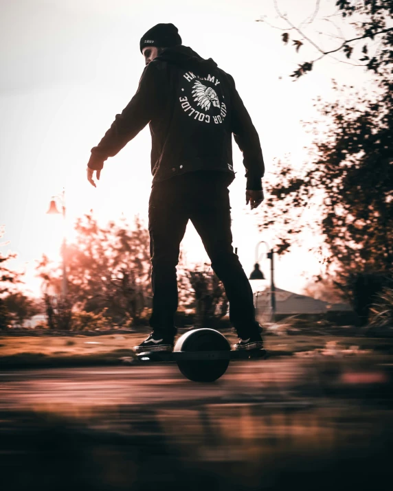 a person is skateboarding down a road at sunset