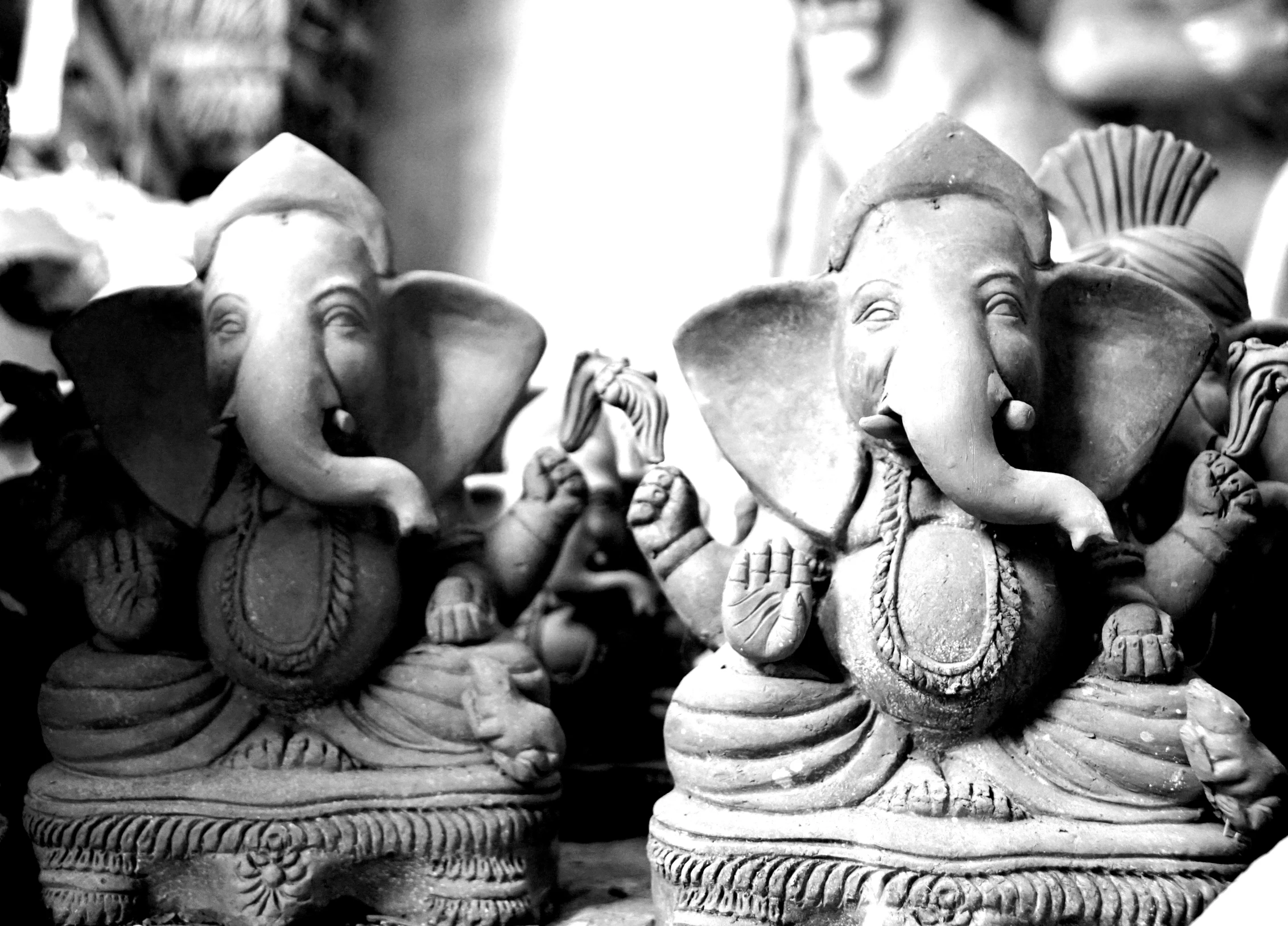 three small gray statues sitting next to each other