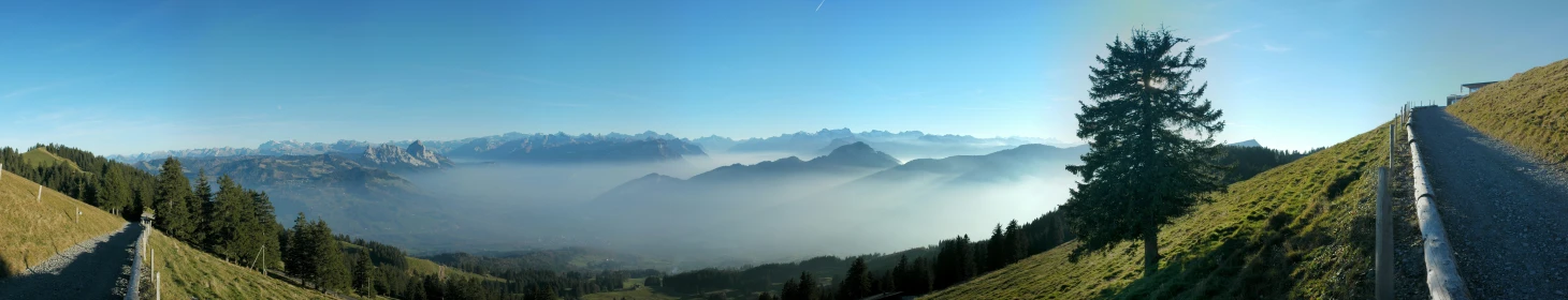 a view from the top of a hill with fog rolling in the valley