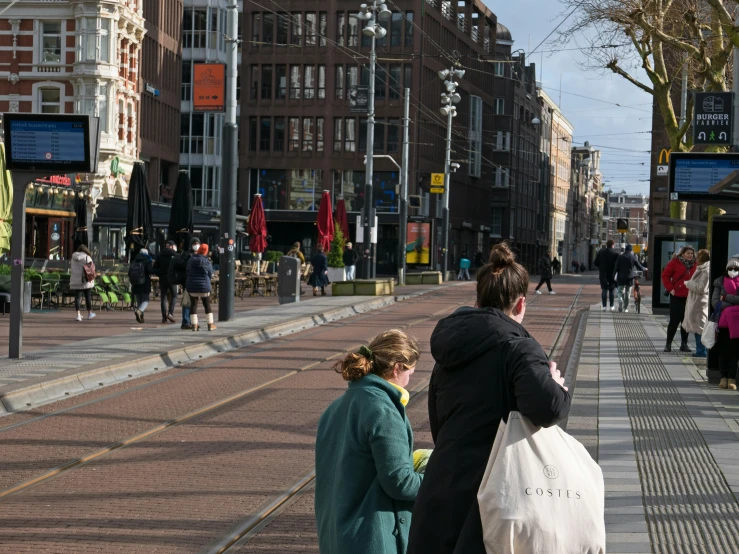 people walk along the side of a street