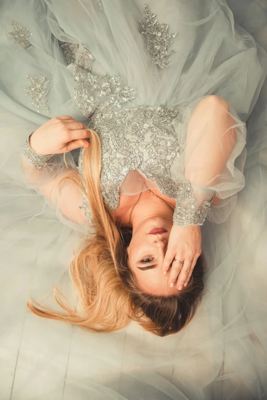 a beautiful woman laying on top of a white bed