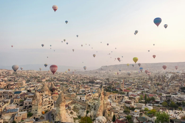 dozens of  air balloons floating above the city