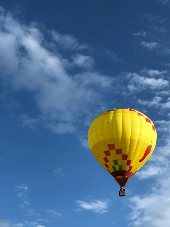 the yellow  air balloon floats in the blue sky