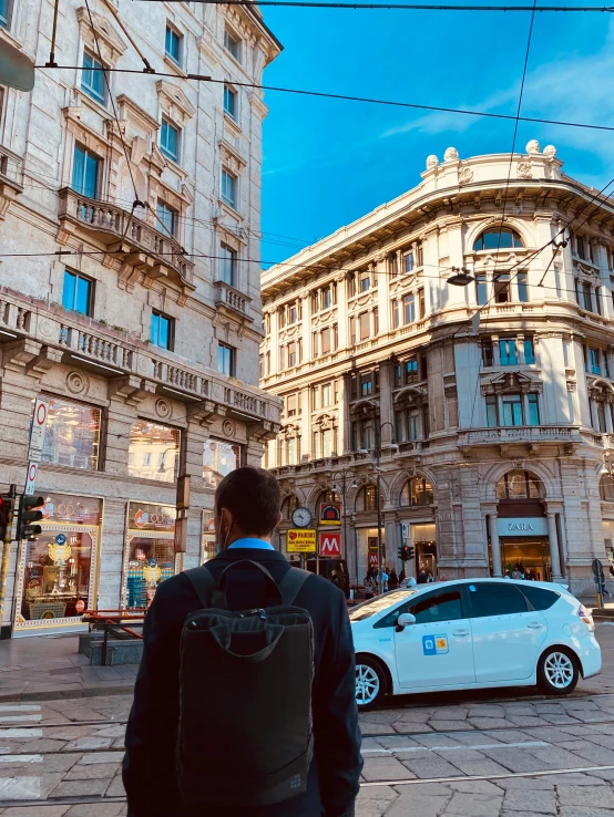 a man is standing in front of a car on the street