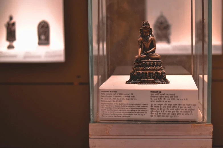 an ornate object of buddhist architecture inside a glass case