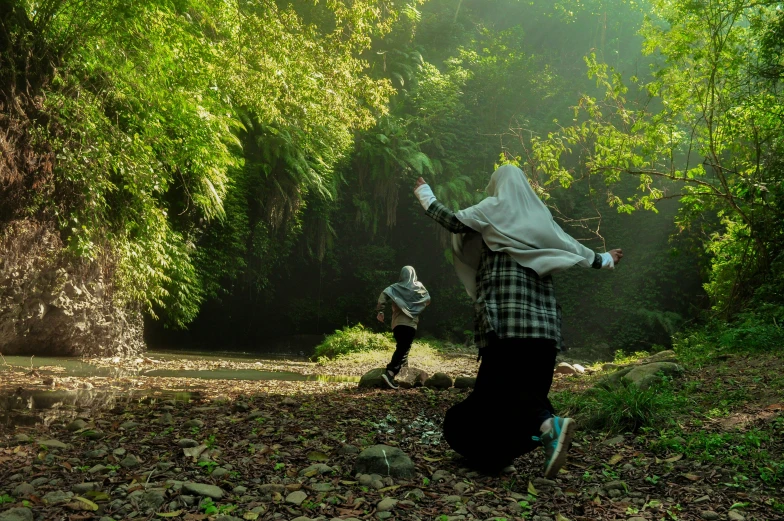 the men are running around a forest trail