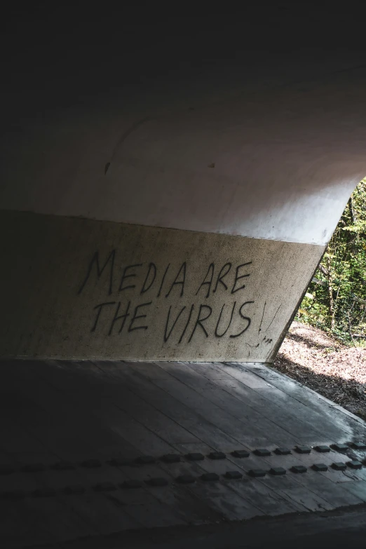 graffiti written on a wall under an overpass