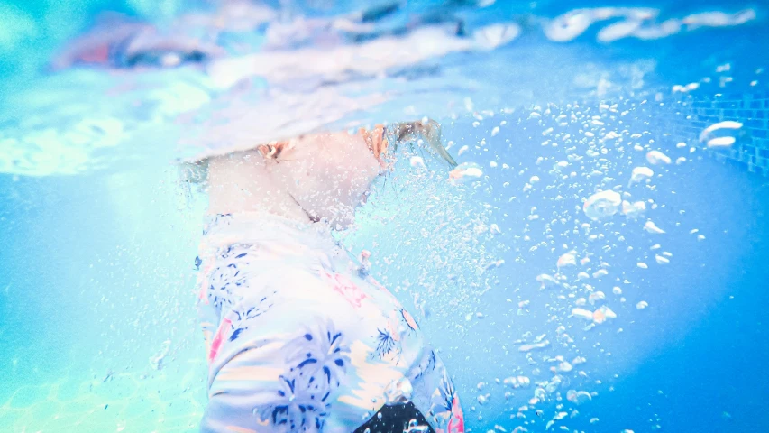 a person swimming under water near a pool