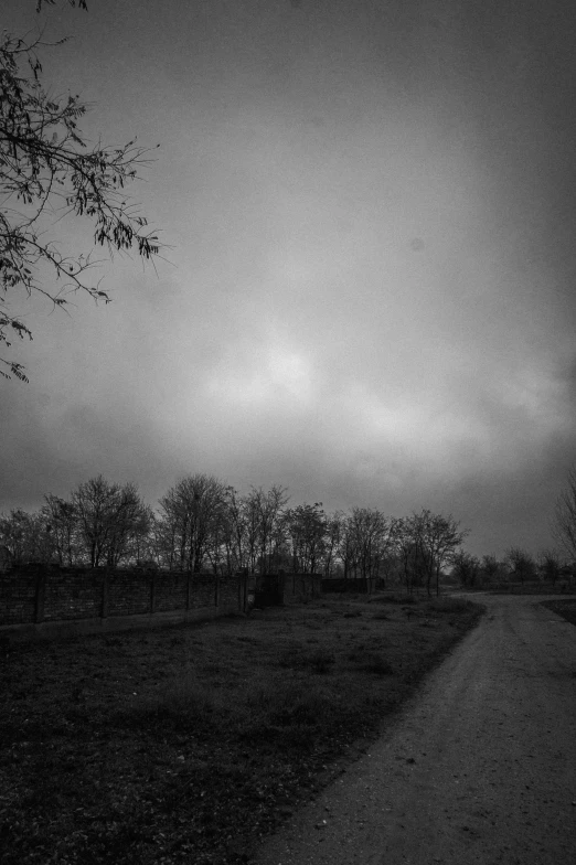 dark night sky and clouds at the end of a long empty road