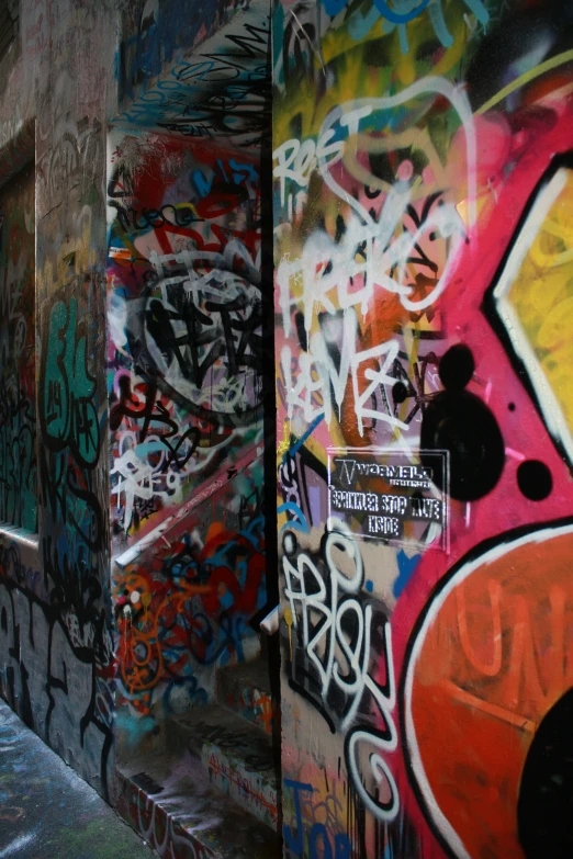 a wall full of colorful graffiti with several different items