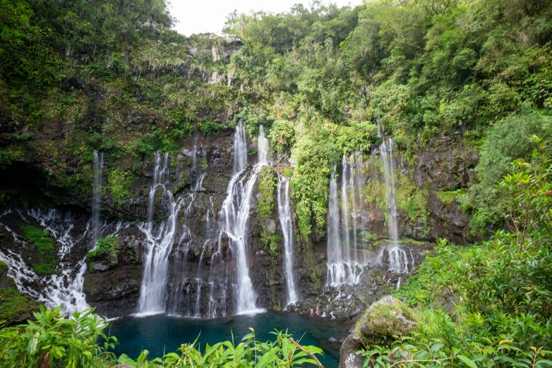 a waterfall with large waterfalls and a pool in the middle