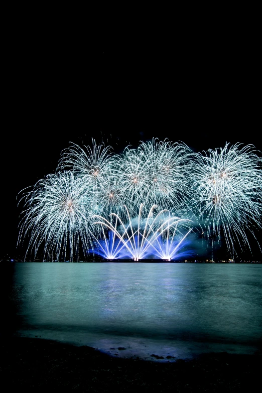 the fireworks show is lit up in the sky over the water