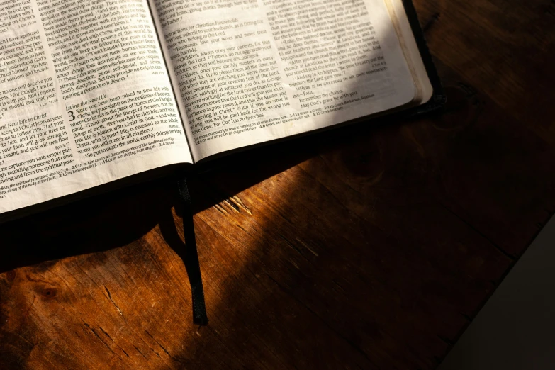 an open book sitting on top of a wooden table