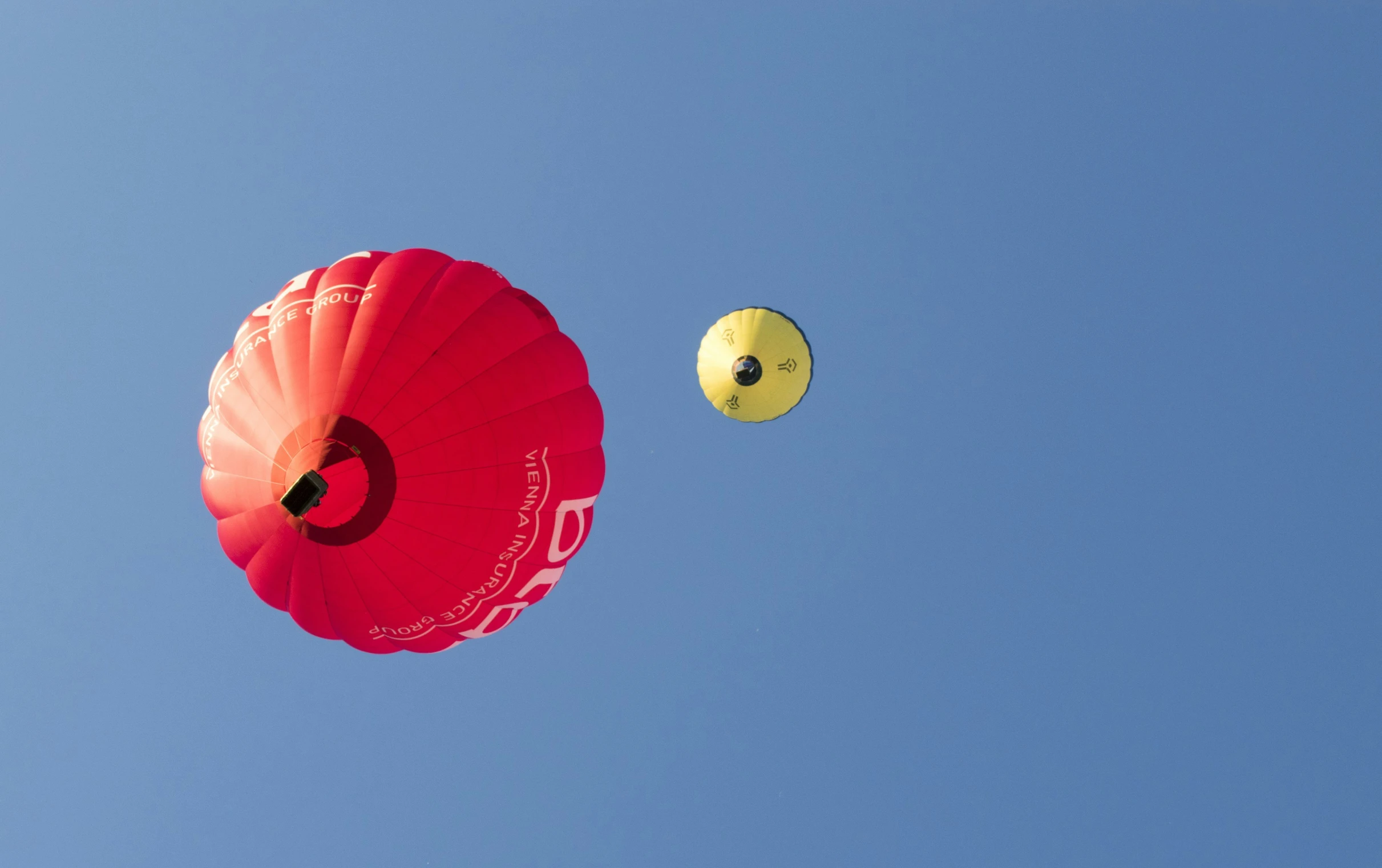 two kites flying high up in the sky