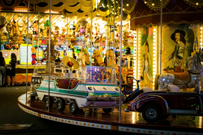 people stand at the carnival and ride a carousel with boats