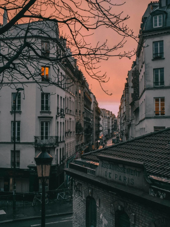 the sun sets over several buildings in a city