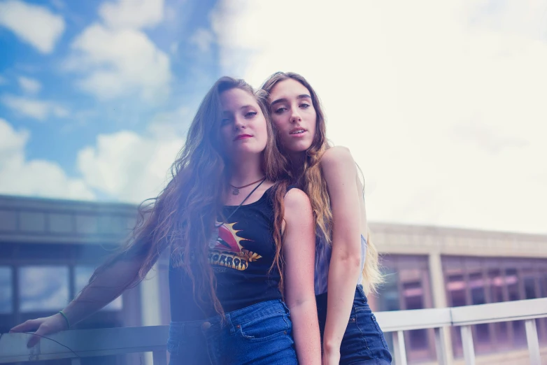 two women posing for a picture outside in front of a building