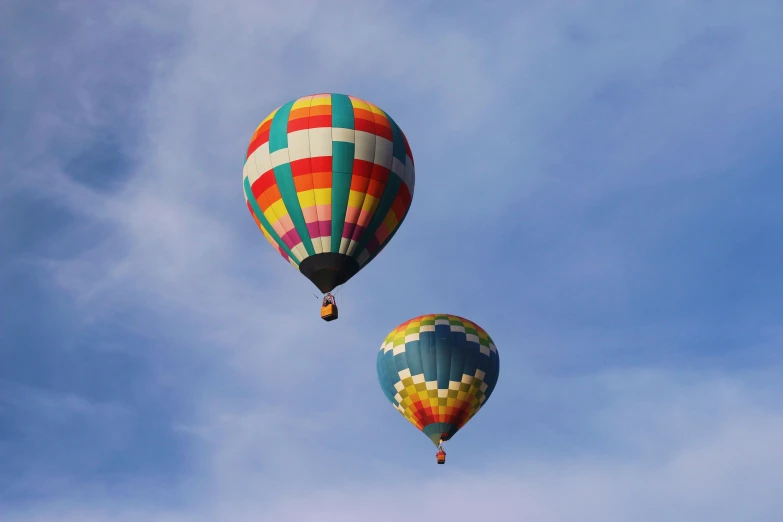 a couple of large balloons floating in the sky