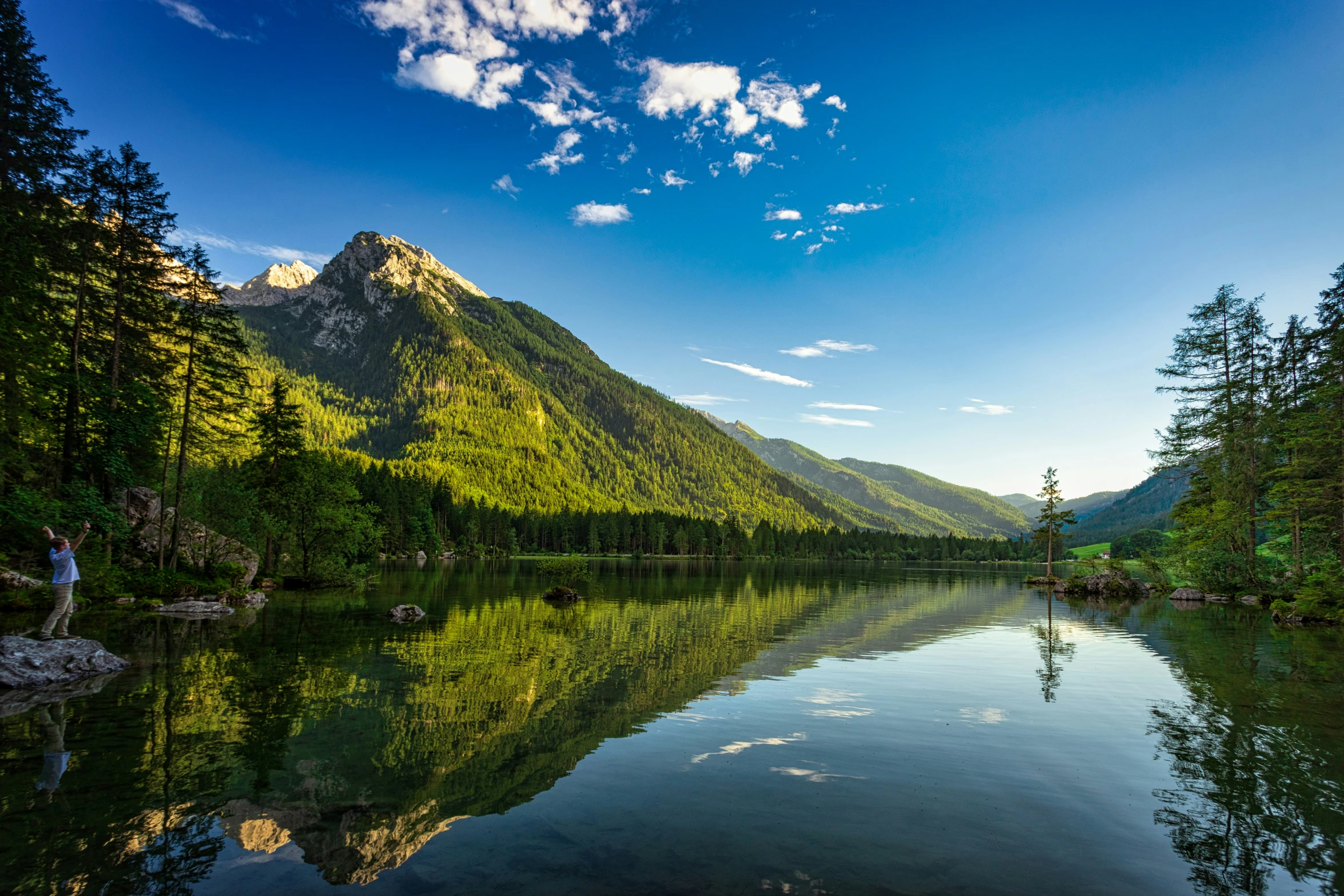 an empty mountain lake with clear water in front of it