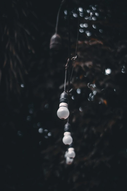 a bunch of hanging light bulbs surrounded by water drops