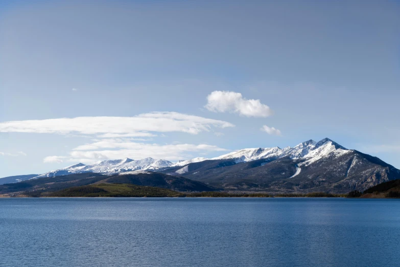 a body of water with mountains behind it