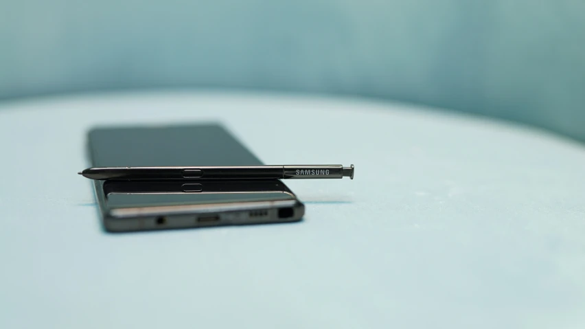 two cell phones sit on a white table