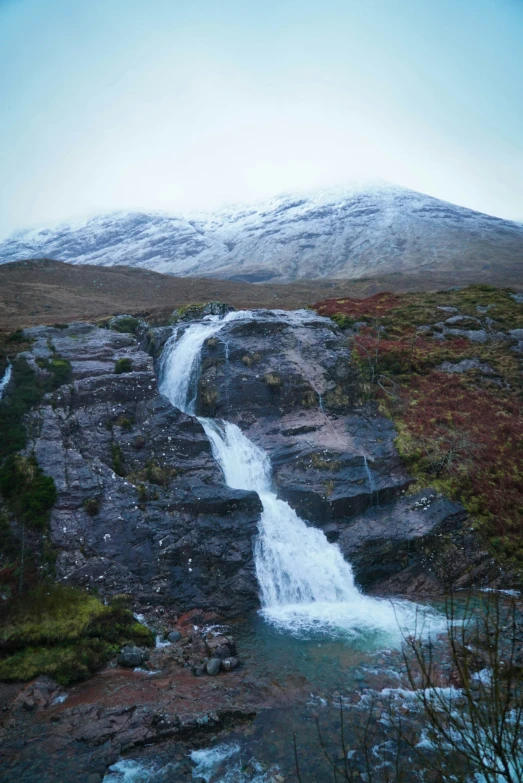 a waterfall running down to the side of a mountain