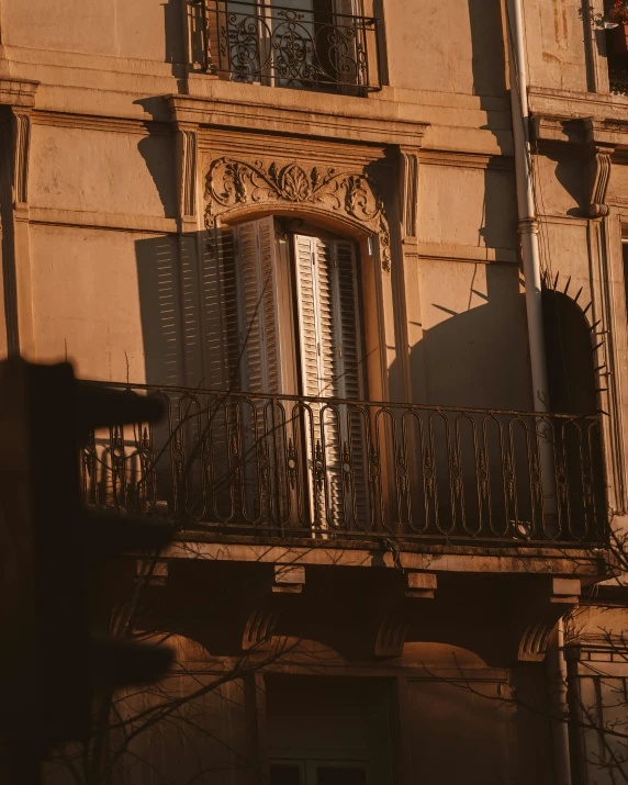 a tall building with several balconies and a clock on the corner