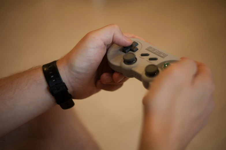 a guy holding up his grey controller for his game