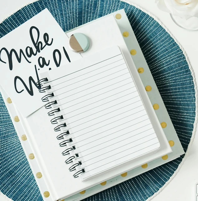 a blue and white plate holding a notepad with the word make me do