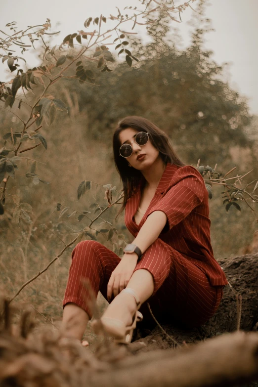 a girl in red dress sitting on tree nch