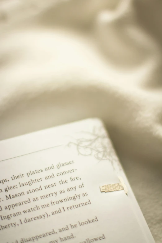 an open book is sitting on a bed