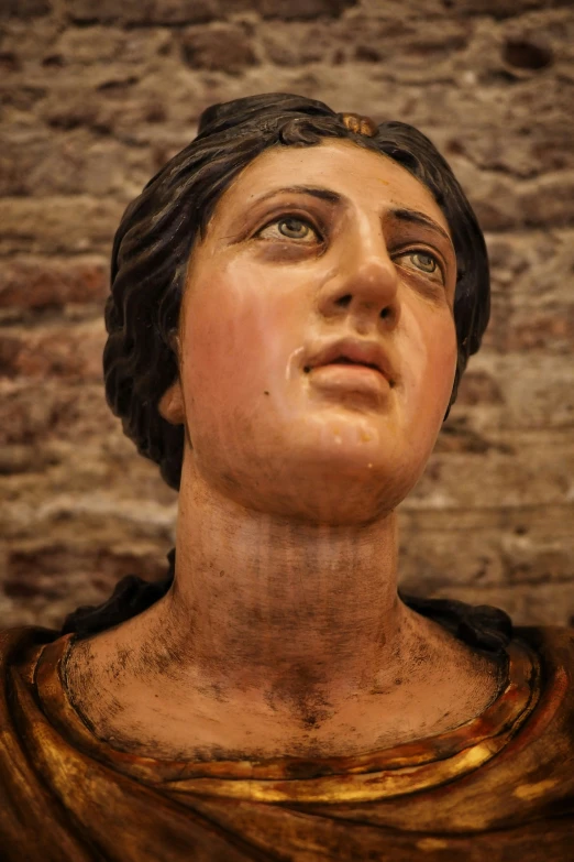 a statue of jesus is shown next to a brick wall