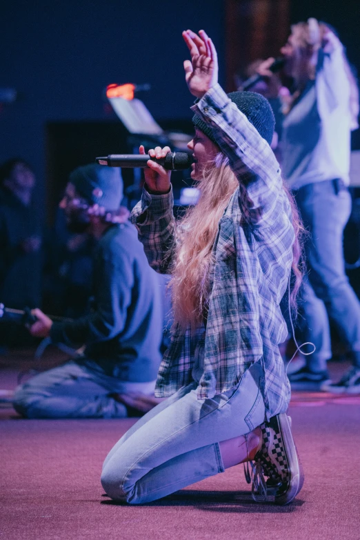 a person kneeling on the ground in front of a microphone