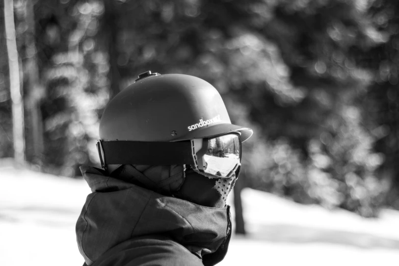 a person wearing a helmet and sunglasses wearing a scarf