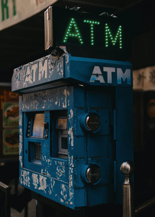 a atm machine with a lit out meter and some signs behind it