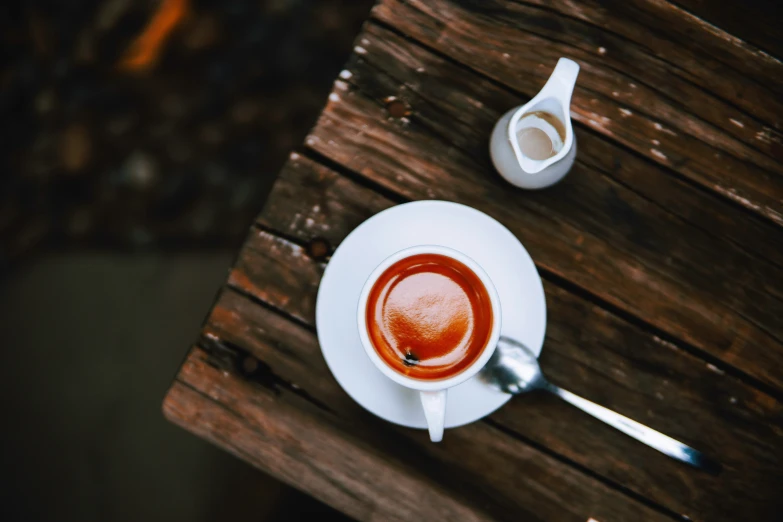 a cup of coffee next to a sugar shaker