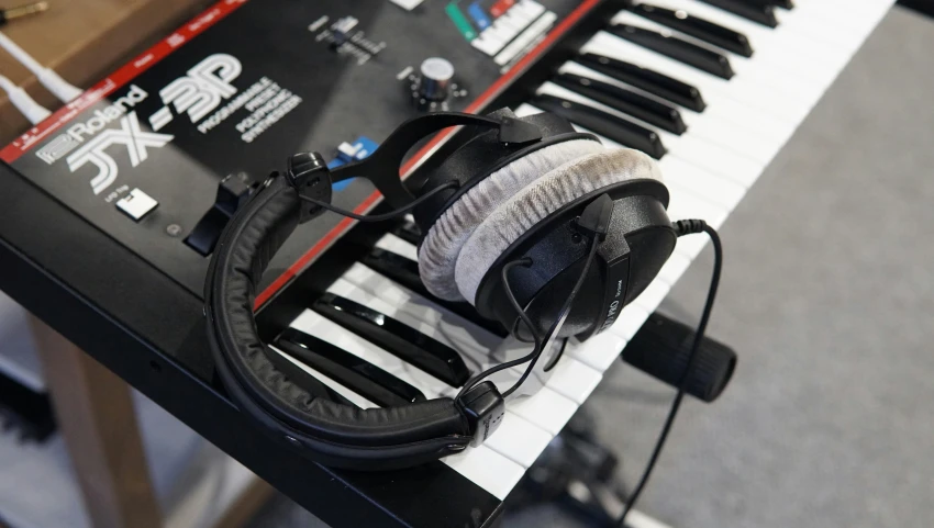 a computer keyboard with earphones and headphones on it