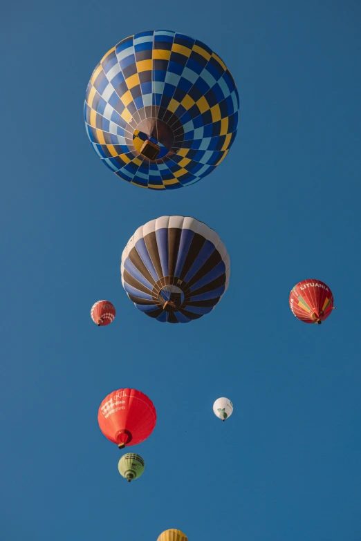 several different colored  air balloons flying up in the sky