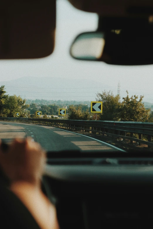 the inside view from inside a car driving down a road