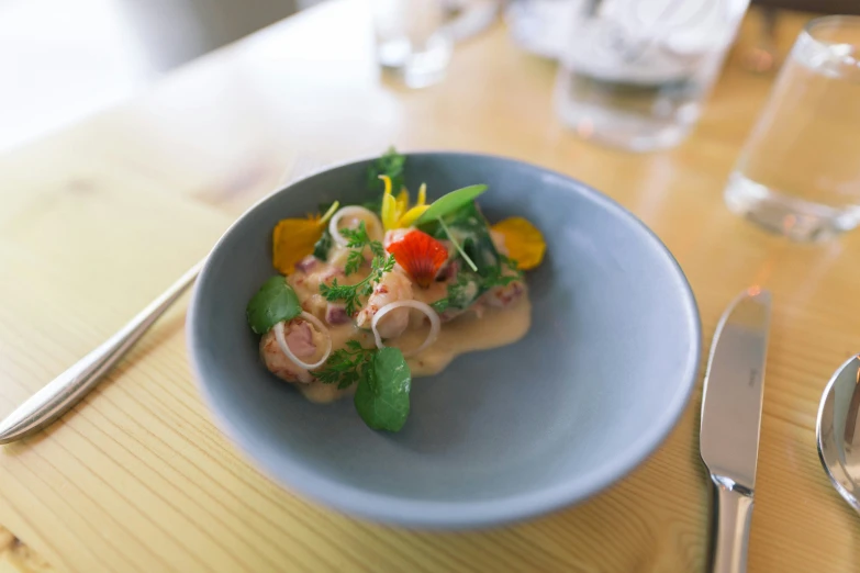 a plate of food in a blue bowl sitting on a table