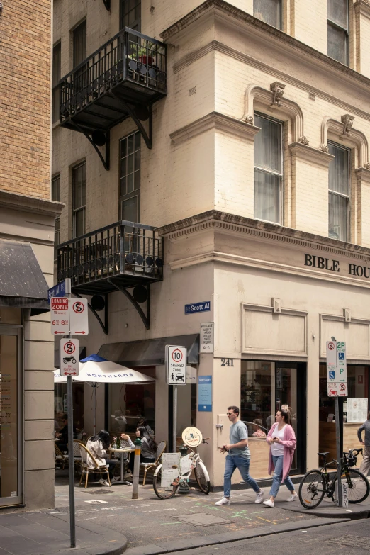 people walking down a city street near stores