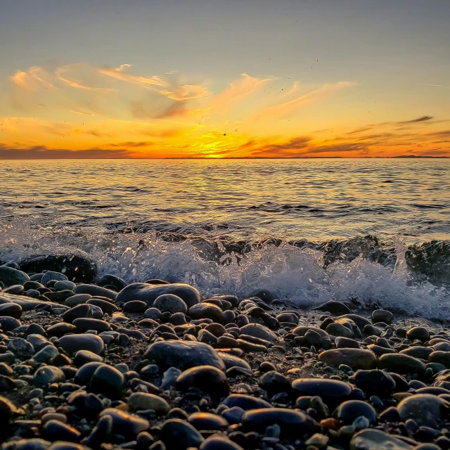 a body of water sitting on top of a rocky beach