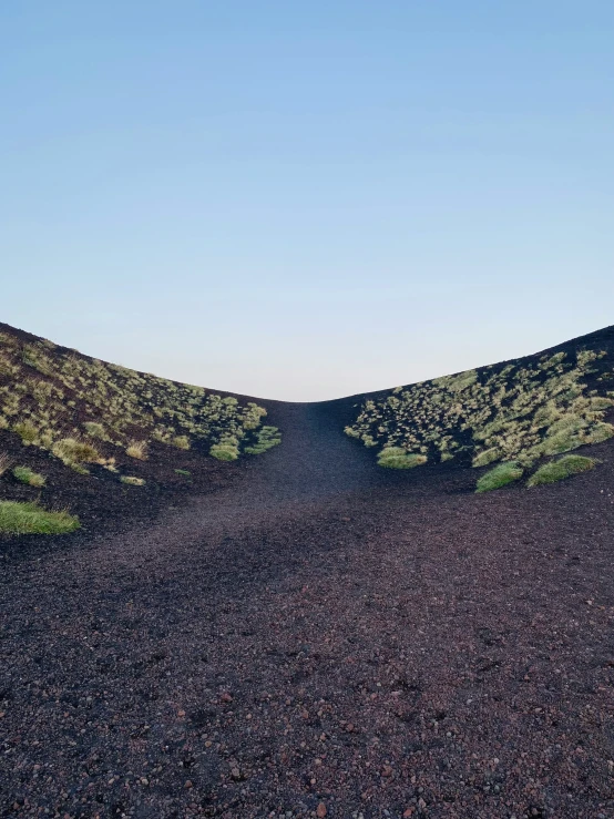 two different types of hills with grass on each side