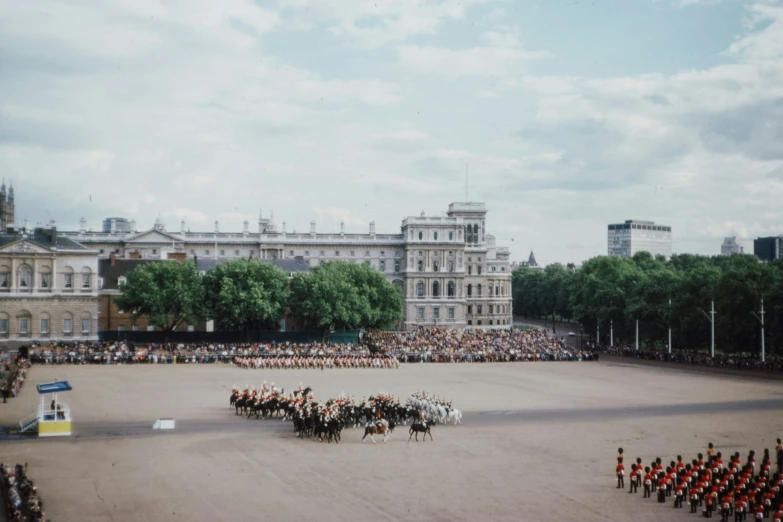 an open area with several mounted horses and a group of people standing