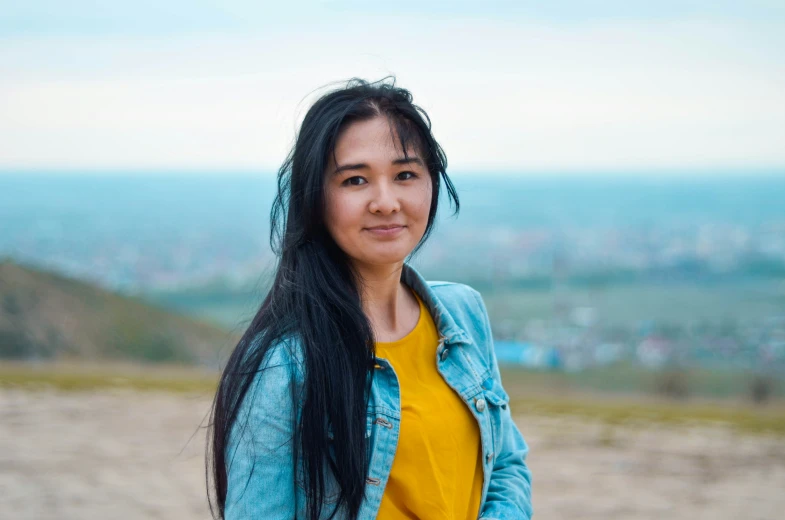 a young woman wearing a yellow shirt and blue jacket