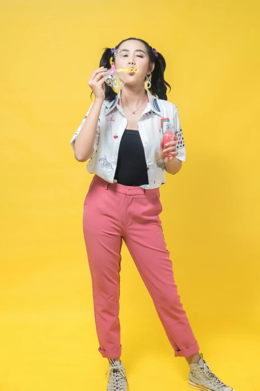 a woman in pink pants and white shirt eating food