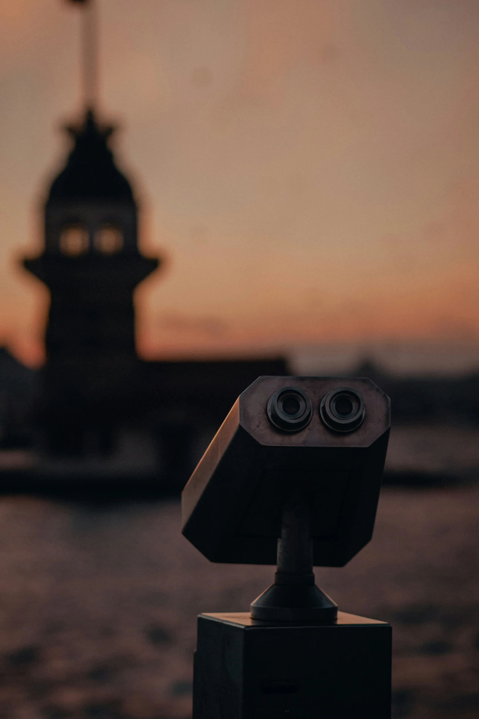 two cameras sitting on top of a wooden table next to a clock tower